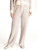 Pantalón de punto tejido color beige melange, de corte holgado y pernera recta con franja lateral en tono crudo. Cuenta con cintura elástica con cordón de ajuste en color crudo.