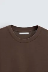 Jersey de algodón de punto, color rosa pálido, con cuello redondo y manga corta, corte relajado.