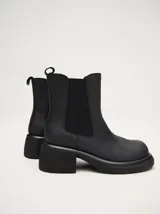 Bota tipo chelsea de cuero vacuno en color rojo con estampado floral grabado en negro. Presenta paneles laterales elásticos, suela de plataforma y taco cuadrado en color negro.