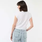 Camiseta blanca de corte cropped con estampado frontal de Mickey Mouse y texto alusivo a Disney.