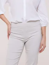 Pantalón color beige de corte entallado y largo cropped, confeccionado en tejido de punto con elasticidad técnica. Cuenta con pretina ancha y plana, bolsillos simulados al frente y bolsillos tipo ojal en la parte posterior.