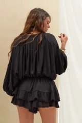 Short pollera negro de tiro alto, confeccionado en tejido texturizado con cintura elástica ajustable mediante cordón, diseño de doble volado y detalles de encaje en los bordes.