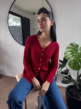 Blusa de morley color rojo, de manga larga y escote en V, con botones dorados en el frente.