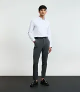 Pantalón de corte slim para hombre, confeccionado en tejido de poliéster, viscosa y elastano. Presenta cintura elástica con trabillas para cinturón, cierre tradicional y bolsillos funcionales.