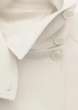 Parka de corte recto en mezcla de lana color blanco, con cuello embudo grande, mangas largas con trabillas, dos bolsillos de solapa laterales y cierre delantero con botones.