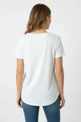 Remera de algodón gris con cuello redondo y mangas cortas. Presenta un estampado frontal con formas abstractas y motivos botánicos en tonos azul, beige y verde.