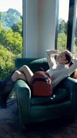 Mochila pequeña de símil cuero color negro, con bolsillo frontal con cierre, asa de mano y correas regulables.