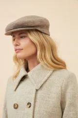 Boina con visera de estilo clásico, confeccionada en lana fina uruguaya 100% natural sin teñir, con textura jaspeada en tonos tierra.