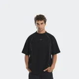 Remera de corte oversize color negro, con costuras decorativas en contraste que recorren el frente y logo bordado centrado en el pecho.