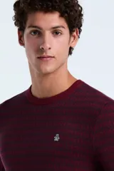 Sweater de punto con diseño geométrico en tonos bordó y negro, cuello redondo, manga larga y puños acanalados. Presenta el logo de la marca bordado en el pecho.