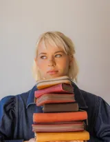 Billetera de cuero color tostado con cierre de cremallera. Interior con seis compartimentos para tarjetas y un compartimento para monedas con cierre. El billete entra doblado.