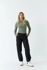 Pantalón cargo color negro de tiro medio, con bolsillos laterales tipo cargo y detalle ajustable en los tobillos.