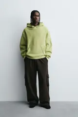Sudadera tipo hoodie con efecto lavado, corte cropped y ajuste holgado. Cuenta con capucha, bolsillo frontal tipo canguro y terminaciones en rib en mangas y ruedo. Interior afelpado.