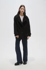 Tapado de lana con diseño a cuadros en tonos marrones y beige, de corte holgado, con cuello de solapa y cierre frontal con botones.