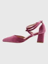 Zapato de tacón cuadrado medio, confeccionado en terciopelo color púrpura. Presenta un diseño de punta fina con tiras cruzadas en el empeine y cierre con hebilla ajustable en el tobillo.