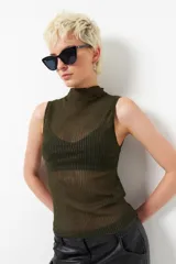 Top negro sin mangas de cuello alto, confeccionado en tela semitransparente con textura acanalada y acabado brillante.