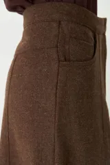 Falda larga de corte recto con bolsillos delanteros y costuras verticales decorativas. Confeccionada en lana fina sin teñir.