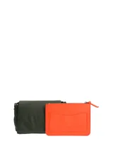 Cartera tipo bandolera Hush Puppies en color verde oliva, con solapa frontal, cierre principal y correa ajustable con detalle de marca.