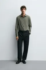 Camisa de corte regular fit color celeste, confeccionada en tejido fácil de planchar. Cuenta con cuello italiano abierto, manga larga con puño abotonado y cierre frontal con botonadura.