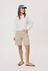 Bermuda de denim color beige, con fit relajado y largo a la rodilla, tiro medio y bolsillos clásicos.
