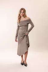 Vestido largo color chocolate, con escote off-shoulder, mangas largas y corte asimétrico.