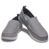 Mocasín Crocs modelo Walu Syn de estilo náutico, confeccionado en lona azul con detalles en color marrón. Presenta suela de material Croslite flexible y diseño slip-on con ojales decorativos laterales.