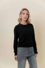 Buzo de punto color beige melange, de manga larga, cuello redondo y corte recto.