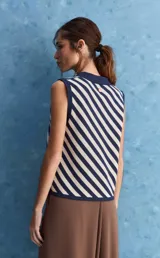 Chaleco tejido de punto con diseño de rayas diagonales en color marrón y beige, cuello polo y escote en V profundo.