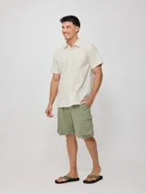 Camisa de manga corta con diseño a rayas verticales finas, cuello clásico y cierre frontal con botones.