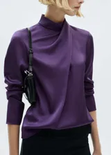 Blusa de tejido satinado color violeta, con cuello alto drapeado y mangas largas.