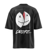 Remera negra de corte relajado con un gran estampado gráfico en la espalda que muestra dos mitades de un rostro sonriente intervenido con cruces en los ojos y un borde rojo. Debajo del gráfico se lee la palabra "DROPZ" en tipografía brush blanca.