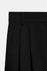 Pantalón de tiro medio con corte wide leg, presenta pliegues frontales, bolsillos laterales y trabilla con botón en la espalda. Cierre frontal con cremallera y botón.