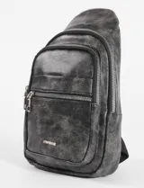 Riñonera cruzada de cuero sintético con acabado efecto desgastado. Cuenta con múltiples compartimentos con cierre metálico y bolsillo vertical en la parte posterior.