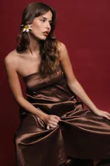 Vestido largo strapless color marrón con efecto tornasolado y bolsillos ocultos.