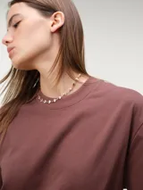 Remera oversize de manga corta color marrón, con cuello redondo y diseño amplio y relajado.