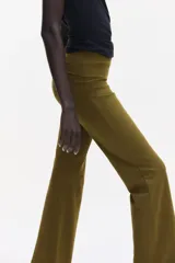 Pantalón de algodón color verde militar, con cintura ancha plegable y perneras de corte recto acampanado.
