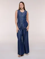 Chaleco de lyocell color azul, con escote redondo, sin mangas, cierre frontal con botones metálicos y bolsillos en la cintura.