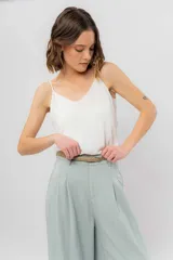 Musculosa de breteles finos con escote en V, confeccionada en tejido fluido con acabado satinado.