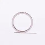 Anillo de acero plateado con una hilera de piedras cuadradas engastadas en el centro.