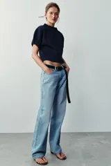 Top de punto color azul marino, con cuello redondo y mangas cortas abullonadas con acabados elásticos fruncidos.