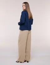 Campera de jean blanca de corte clásico, con cuello solapa, cierre frontal de botones metálicos y bolsillos aplicados con solapa en el pecho.