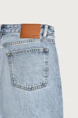 Jeans flare fit de denim negro, tiro medio, ajustados arriba y con botamanga acampanada. Cuentan con cinco bolsillos, lavado efecto gastado y bajo con acabado irregular. Cierre frontal con cremallera y botón.