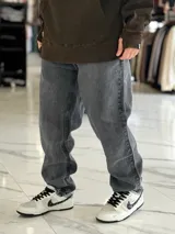 Pantalón de jean gris con efecto deslavado, de corte oversize y diseño holgado con piernas anchas.