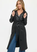 Trench largo de cuero sintético negro con solapas anchas, cierre frontal cruzado y cinturón ajustable en la cintura. Presenta detalles de tejido acanalado en la zona de la cintura y bolsillos laterales.