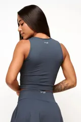 Musculosa deportiva de cuello redondo, confeccionada en poliamida texturizada con calce ajustado al cuerpo y forro frontal para mayor sujeción.