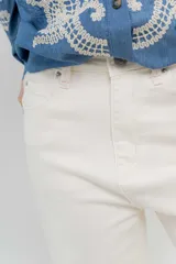 Jean de tiro alto, recto a la pierna, con cinco bolsillos, cierre frontal con cremallera y un botón. Pespunte en rosa.