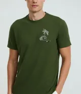 Remera verde militar de algodón texturizado, corte regular, cuello redondo y mangas cortas. Estampa tropical de una casa y palmeras en el pecho.