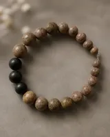 Collar de cuentas esféricas de piedra natural de Jaipur en tonos tierra y tres piedras volcánicas negras, con cierre metálico.
