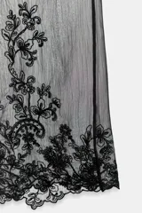 Pantalón semitransparente de tiro medio, pernera recta, cintura ajustable con lazada y detalle de bordados a tono en el bajo.