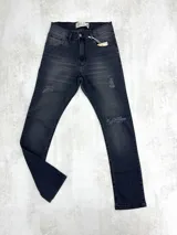 Pantalón jean negro skinny con roturas en las rodillas y muslos.